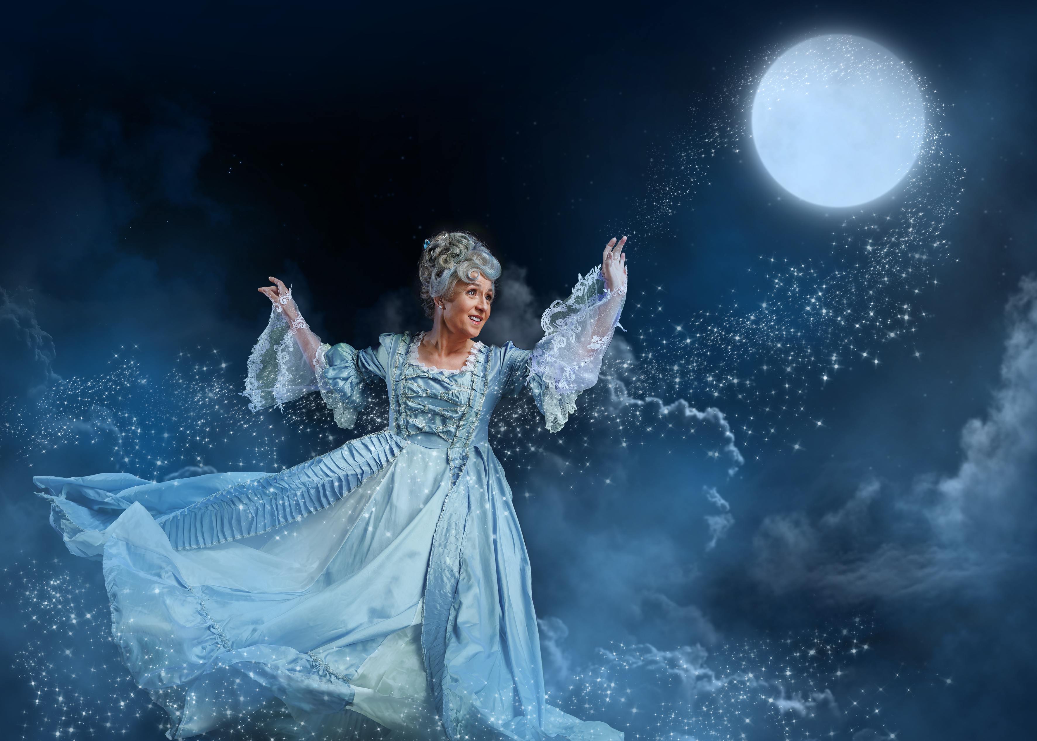 Fairy godmother character creating sparkles under a full moon in a theatrical scene